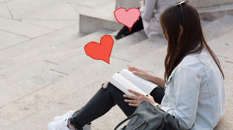 Columbia student reading book on Low Library steps