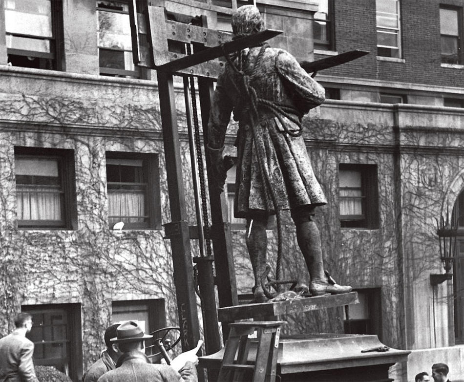 Historic photo of workers installing a sculpture of Alexander Hamilton on Columbia campus, outside Hamilton Hall
