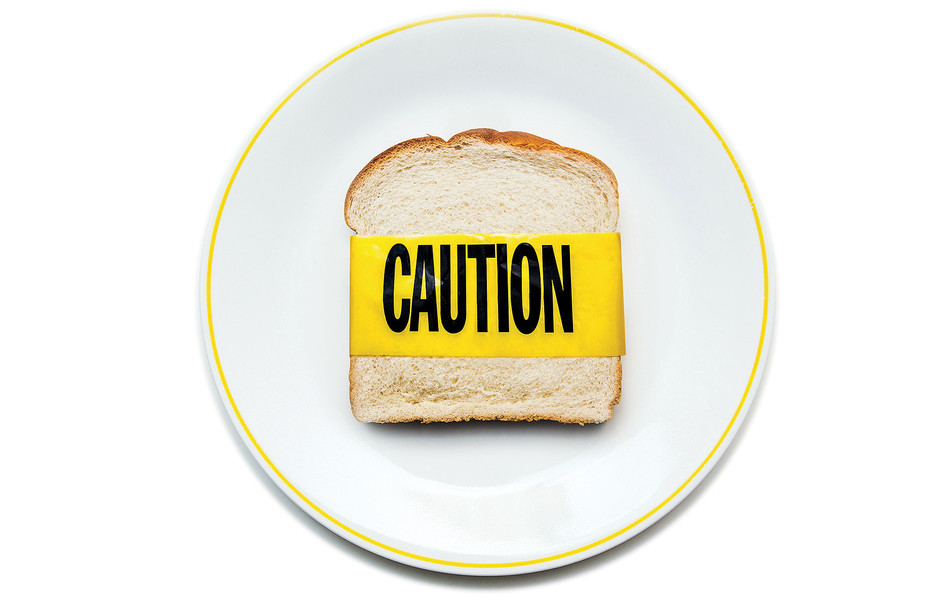 A piece of bread with caution tape to illustrate gluten sensitivity 
