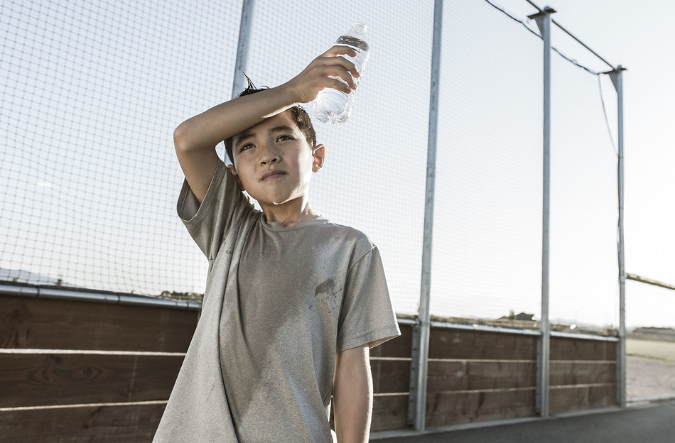A sweaty child with a bottle of water