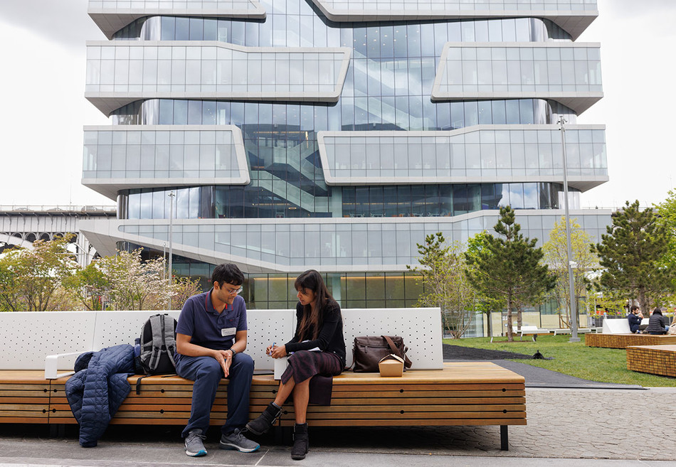 Two people on a bench outside Columbia Business School